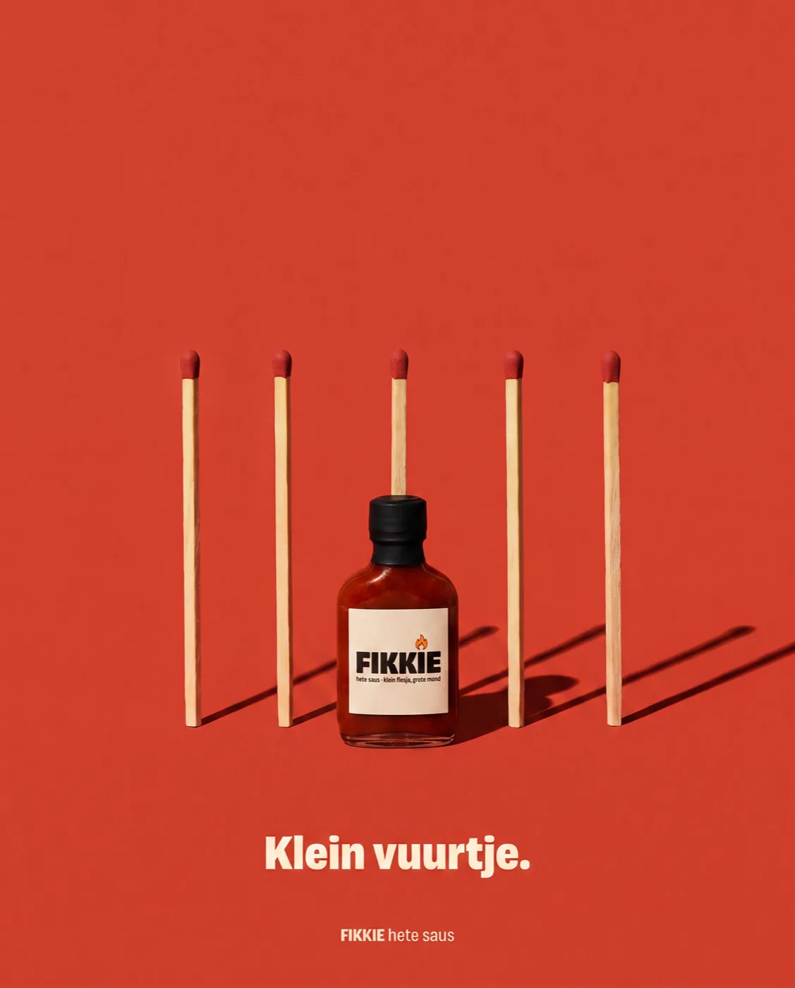 FIKKIE-flesje tussen rechtopstaande lucifers van dezelfde lengte — Klein vuurtje